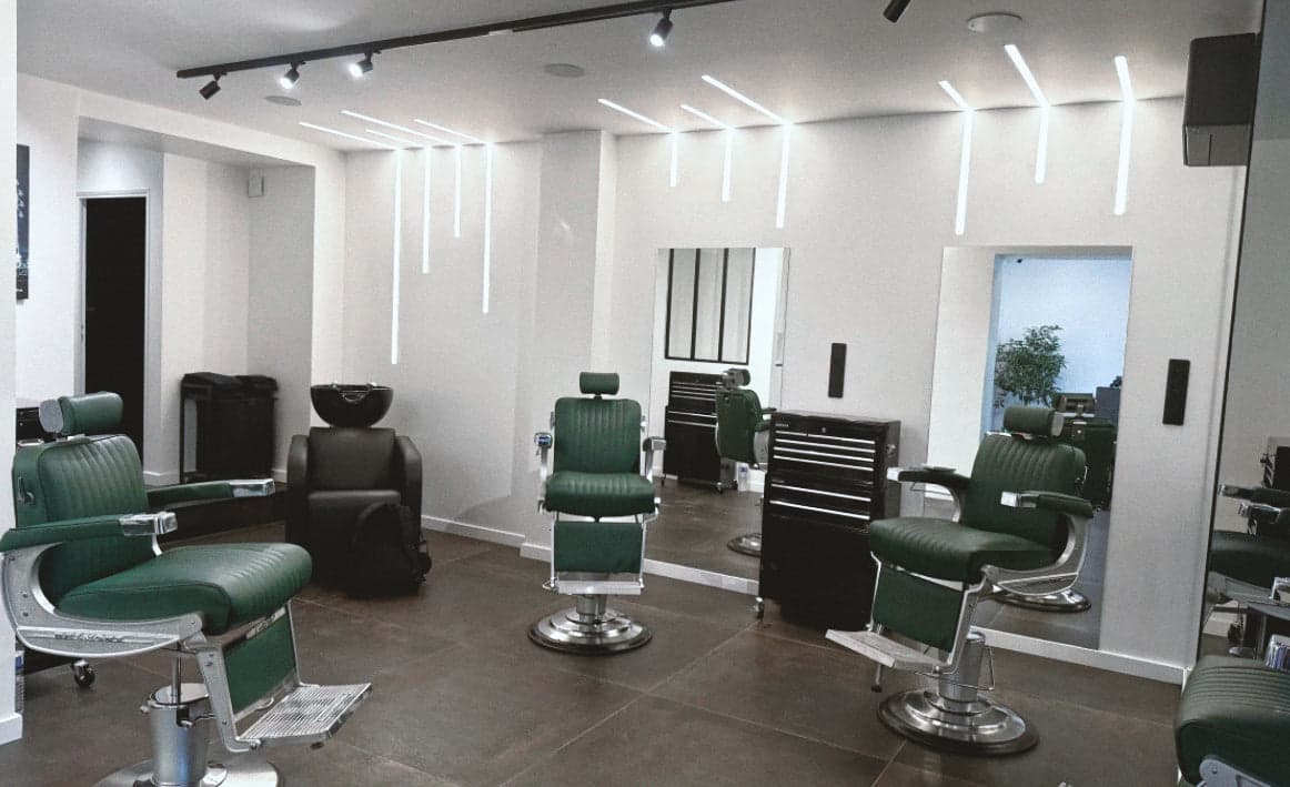 Intérieur du salon Mabden : fauteuils de barbier et miroirs